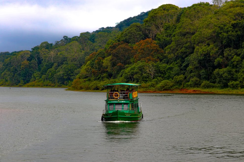 A boat on Periyar lake, Thekkady, surrounded by forest